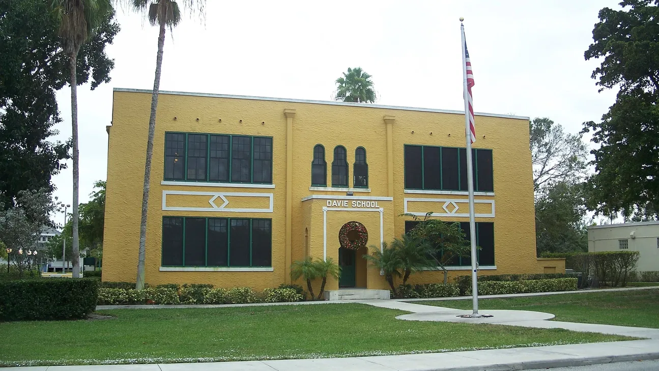 Historic Old Davie School building beneath palms in Davie, Florida